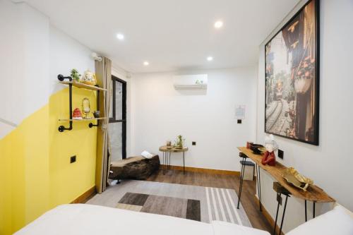 a room with a bed and a yellow door at Rik Homestay in Hanoi