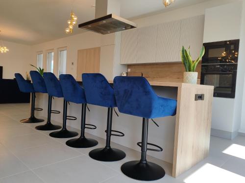 a row of blue bar stools in a kitchen at Villa Zéta Wine & Spa in Mád
