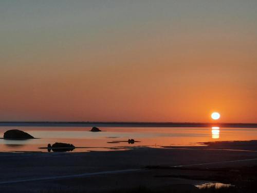 a sunset on the beach with the sun setting at Siwa Salt Lake Lodge in Siwa