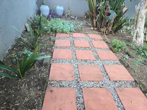 a brick walkway in a garden with plants at The Calm Views Holiday Home in Hazyview
