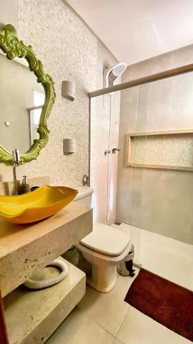 a bathroom with a sink and a toilet and a mirror at CasaBelgaBrasil in Prado