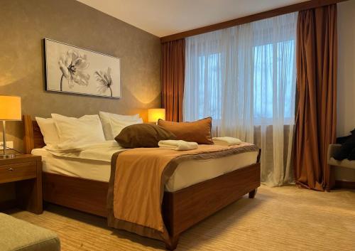 een slaapkamer met een bed en een groot raam bij Apartments B137 & B027 - Aparthotel Vučko in Jahorina