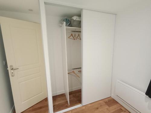 a walk in closet with a mirrored door at 6 personnes / Proche Disney et aéroport CDG in Annet-sur-Marne