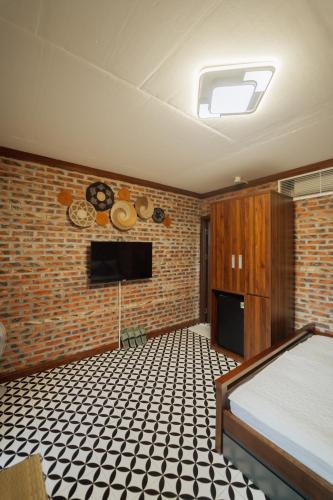 a bedroom with a bed and a brick wall at Xuân Anh Garden in Ninh Binh