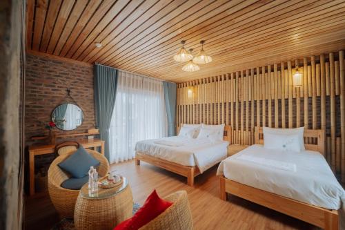 a hotel room with two beds and a chair at Xuân Anh Garden in Ninh Binh