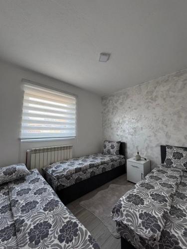 a bedroom with two beds and a window at Apartman ALEA in Pale