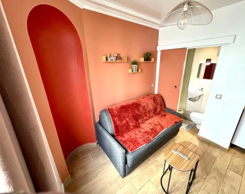 a living room with a red chair and a toilet at HSH - Studio lumineux en plein coeur de Paris in Paris