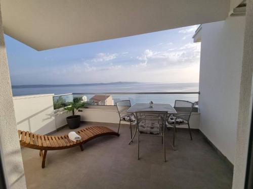 a balcony with a table and chairs and the ocean at Apartments Gabriela in Drasnice