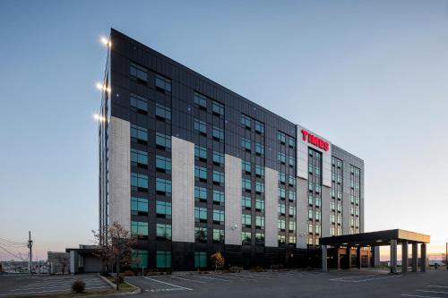 a large building with a parking lot in front of it at Grand Times Hotel in Quebec City