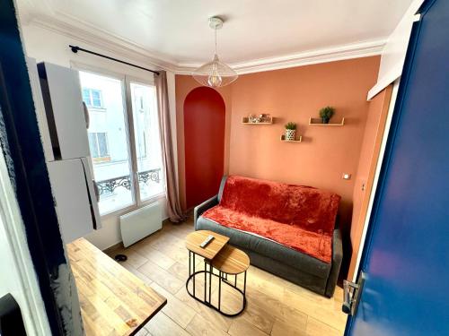 a small living room with a couch and a table at HSH - Studio lumineux en plein coeur de Paris in Paris
