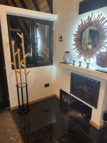 a living room with a fireplace and a mirror at Maison Boho Kremna in Durdići