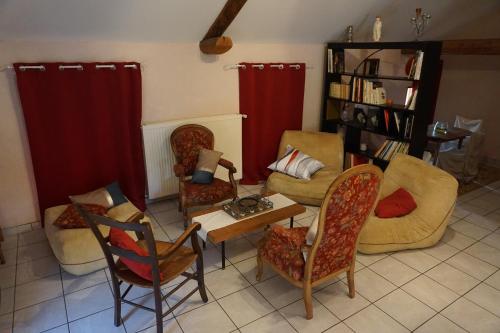 un salon avec des canapés, des chaises et une table dans l'établissement Gîte de Ribeyre, à Saint-Ilpize