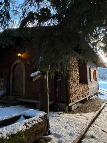 a log cabin in the snow next to a building at Walters Hütte in Tulfes