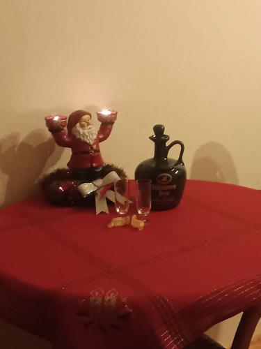 a table with a red table cloth with a candle and wine glasses at STĀRĶA APARTAMENTI in Kuldīga