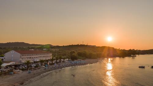 a view of a beach with the sun setting at Aphrodite Beach Hotel Corfu in Roda