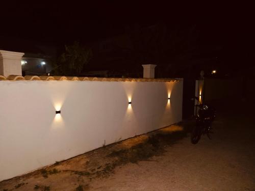 two lights on a white wall at night at Relaxrooms, room with 2 single beds in Agios Georgios