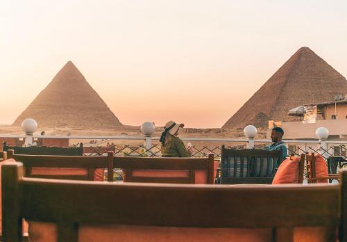 Leute, die vor den Pyramiden sitzen in der Unterkunft BrassJimmy pyramids view in Kairo