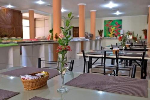 un tavolo con un vaso fiorito in un ristorante di Promoção 09 Bahia Portobello Park a Porto Seguro