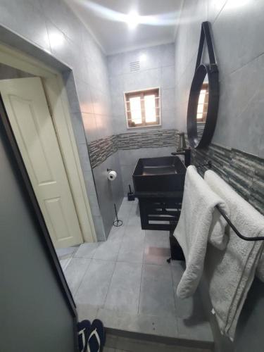 a bathroom with a sink and a mirror at Lovely 1 bedroom self catering apartment in Lusaka