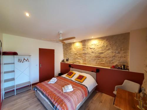 a bedroom with a bed and a brick wall at Au Moulin du Miech in Salvagnac