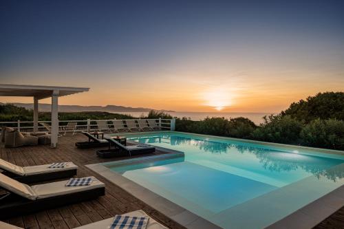 ein Swimmingpool mit einem Sonnenuntergang im Hintergrund in der Unterkunft Villa La Bitta in Badesi