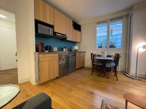 une cuisine avec une table et une salle à manger dans l'établissement Le Fleury, à Paris