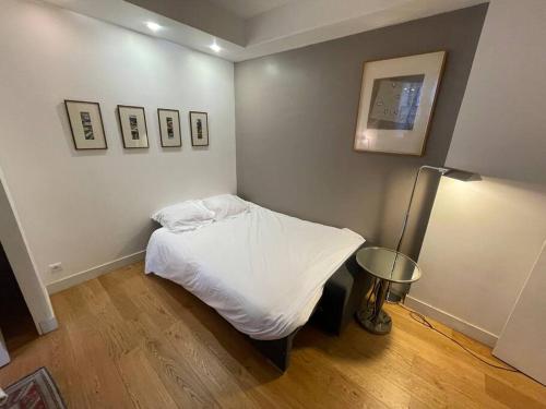 une chambre avec un lit blanc dans une pièce dans l'établissement Le Fleury, à Paris