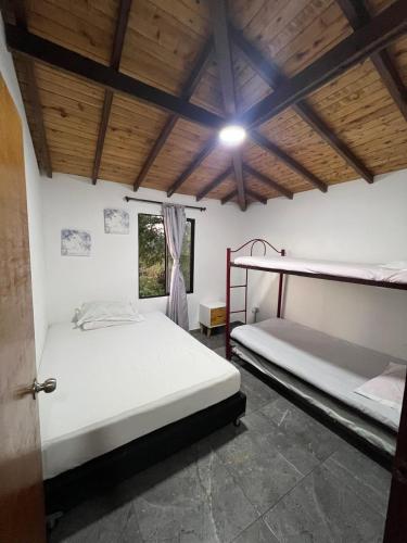 a bedroom with two bunk beds and a window at Cabaña Las Flores en Guatapé in El Peñol