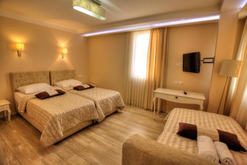 a hotel room with two beds and a television at Boutique Hotel Sulić in Međugorje