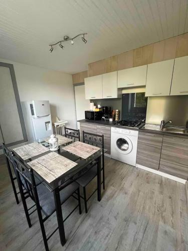 une cuisine avec une table et des chaises dans une pièce dans l'établissement Agréable dépendance pour un séjour paisible à la campagne, à Cerizay