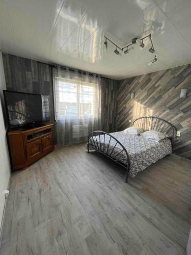 une chambre avec un lit et une télévision à écran plat dans l'établissement Agréable dépendance pour un séjour paisible à la campagne, à Cerizay
