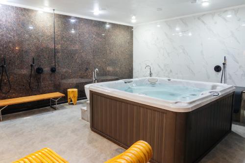 a large bathroom with a tub and a shower at SULO VIP Spa in Atyraū