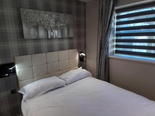 una camera da letto con un letto bianco con una finestra di Beachview apartment a Cleveleys