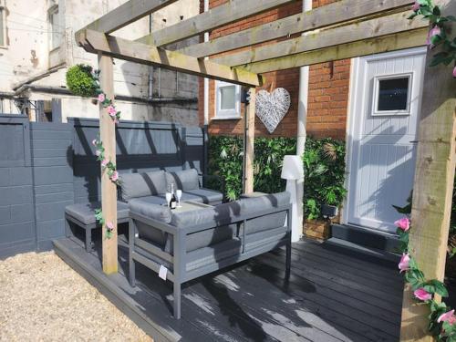 a wooden pergola with a bench on a deck at Beachview apartment in Cleveleys