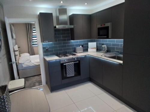 a kitchen with a stove top oven next to a room at Beachview apartment in Cleveleys