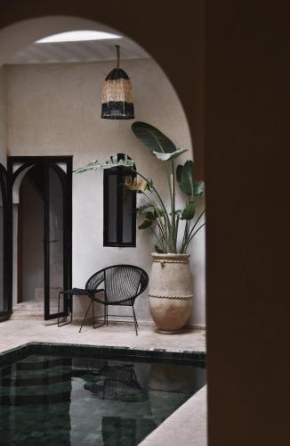 マラケシュにあるRiad Soulmateのプール横の鉢植えと椅子