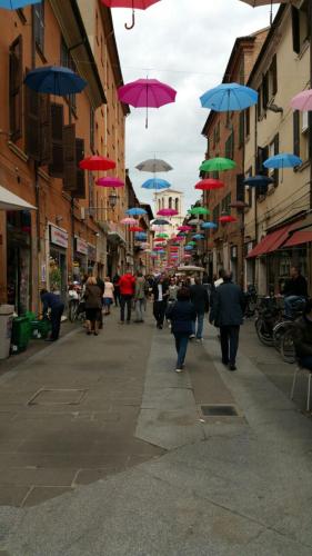 a group of people walking down a street with umbrellas at Ada B&B in Ferrara