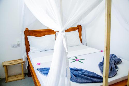 a bedroom with a bed with a canopy at Pamoja Beach Stays Hotel in Jambiani in Jambiani