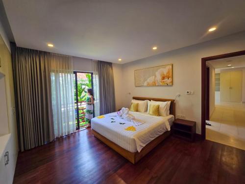 a bedroom with a bed and a sliding glass door at Angkor Mansion & Apartment in Siem Reap