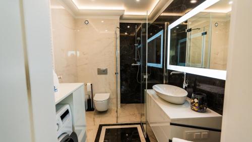 Un baño con lavabo y ducha en Apartament ODNOWA z bezpośrednim widokiem na morze w Gardenia Dziwnów -, en Dziwnów