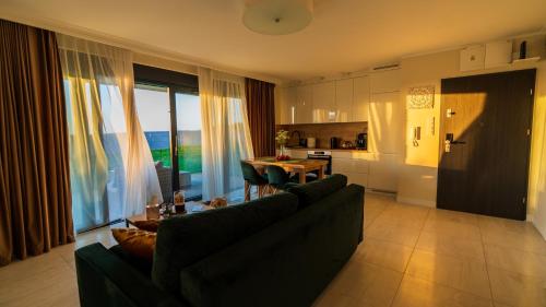Una sala de estar con un sofá y una mesa y una cocina. en Apartament ODNOWA z bezpośrednim widokiem na morze w Gardenia Dziwnów -, en Dziwnów