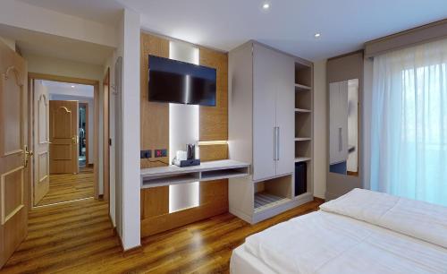 a bedroom with a bed and a flat screen tv at Hotel Madonna delle Nevi in Folgarida