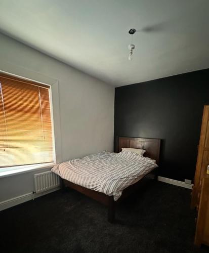 a bedroom with a bed and a black wall at Hallifield house in Stockton-on-Tees