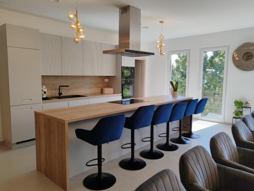 a kitchen with a island with blue bar stools at Villa Zéta Wine & Spa in Mád