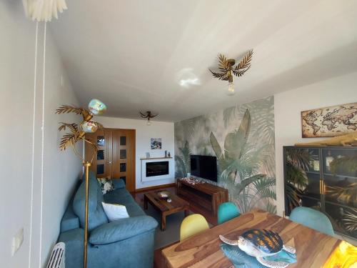 a living room with a blue couch and a table at Apartamento Capricho Finisterre Playa in Finisterre