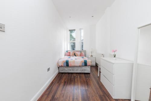a white bedroom with a bed and a window at Two Bedroom Apartment At Heart Of Hanwell in Hanwell