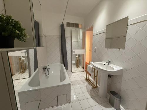 une salle de bain blanche avec une baignoire et un lavabo dans l'établissement Sublime appartement 4P classé dans le Vieux-Nice, à Nice