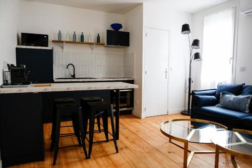 une cuisine et un salon avec un comptoir et des chaises dans l'établissement Le Jardin de Beau Pré - App 3-2 - Centre ville, à Perpignan