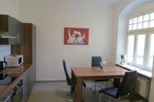 eine Küche mit einem Holztisch und Stühlen im Zimmer in der Unterkunft DD-Rent Dresden Apartment in Dresden