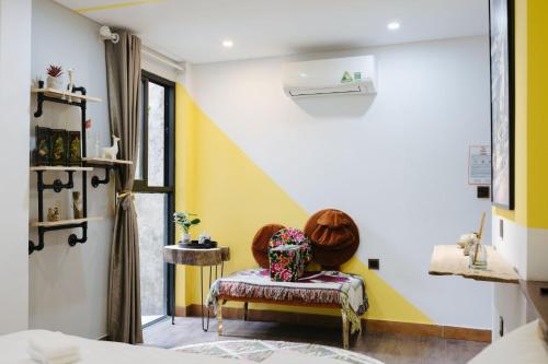 a room with yellow and white walls and a bench at Rik Homestay in Hanoi